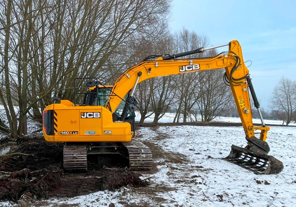 Koparka gąsienicowa JCB 140X LC o szerokich gąsienicach, pracująca na zaśnieżonym i podmokłym terenie.