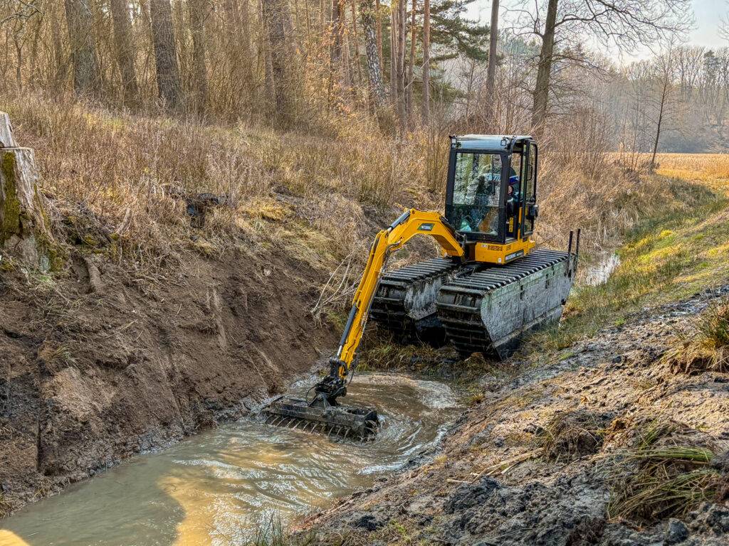 Koparka pływająca Waterking WK20 czyści rów z roślinności i osadów w trudno dostępnym terenie.