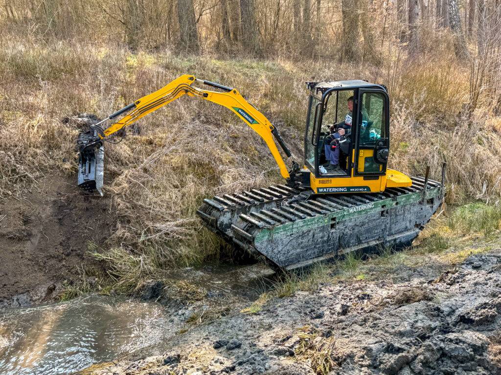 Koparka pływająca Waterking WK20 czyści rów z roślinności i osadów w trudno dostępnym terenie.