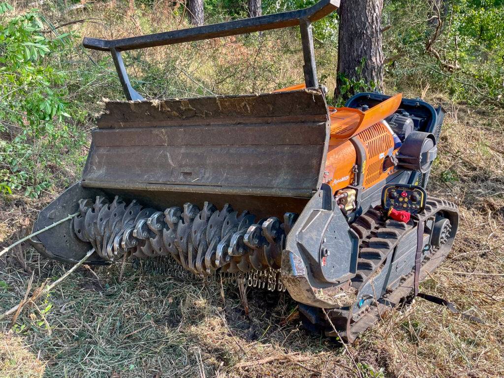 Kosiarka jednoosiowa BCS 630 WS z głowicą mulczującą leśną podczas pracy na trudnym, zalesionym terenie.
