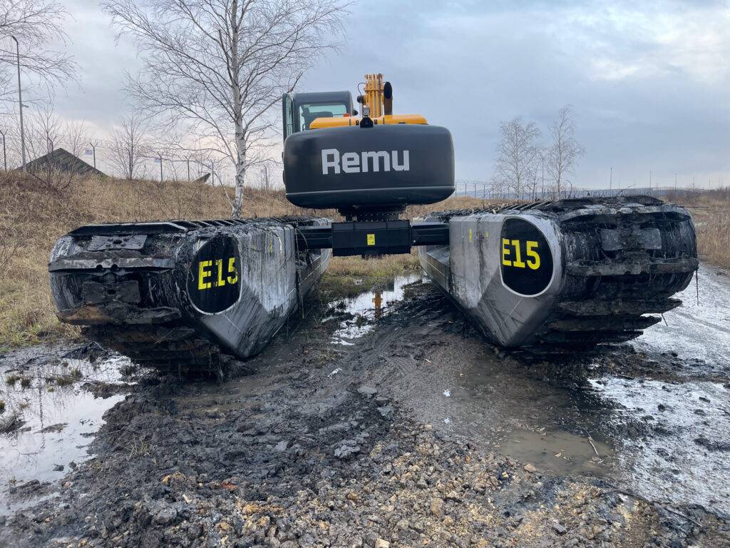 Koparka pływająca REMU BIG FLOAT E15 sfotografowana od przodu – widoczne szerokie pływaki i stabilna konstrukcja do pracy w błocie i wodzie.